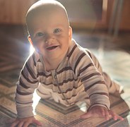 baby_crawling_sitting_floor_smiling_eyes_open_wide